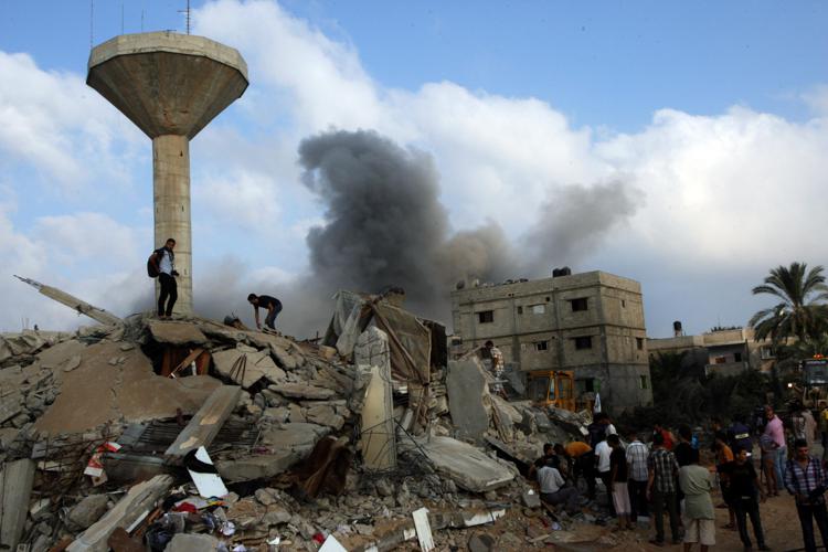 Smoke rises as Palestinian rescuers search for victims under the rubble of the home of the Duheir family which was destroyed following an Israeli air strike on Rafah in the southern of Gaza strip, on July 29, 2014. More than 100 Palestinians were killed on Tuesday, a day after 10 Israeli soldiers were killed in Gaza. UPI/Ismael Mohamad - Infophoto - INFOPHOTO
