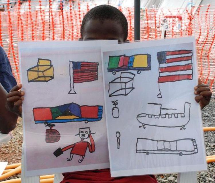 Nella foto, Momodu, il bimbo di 10 anni sopravvissuto all'Ebola, mostra i disegni fatti durante la permanenza nel  Centro Msf di Monrovia, Liberia (foto Msf)