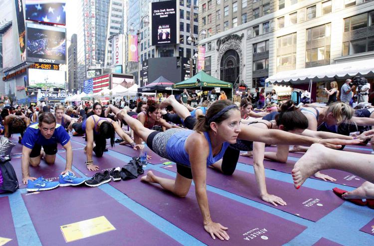 Migliaia di persone praticano yoga a Times square a New York.  - (INFOPHOTO)