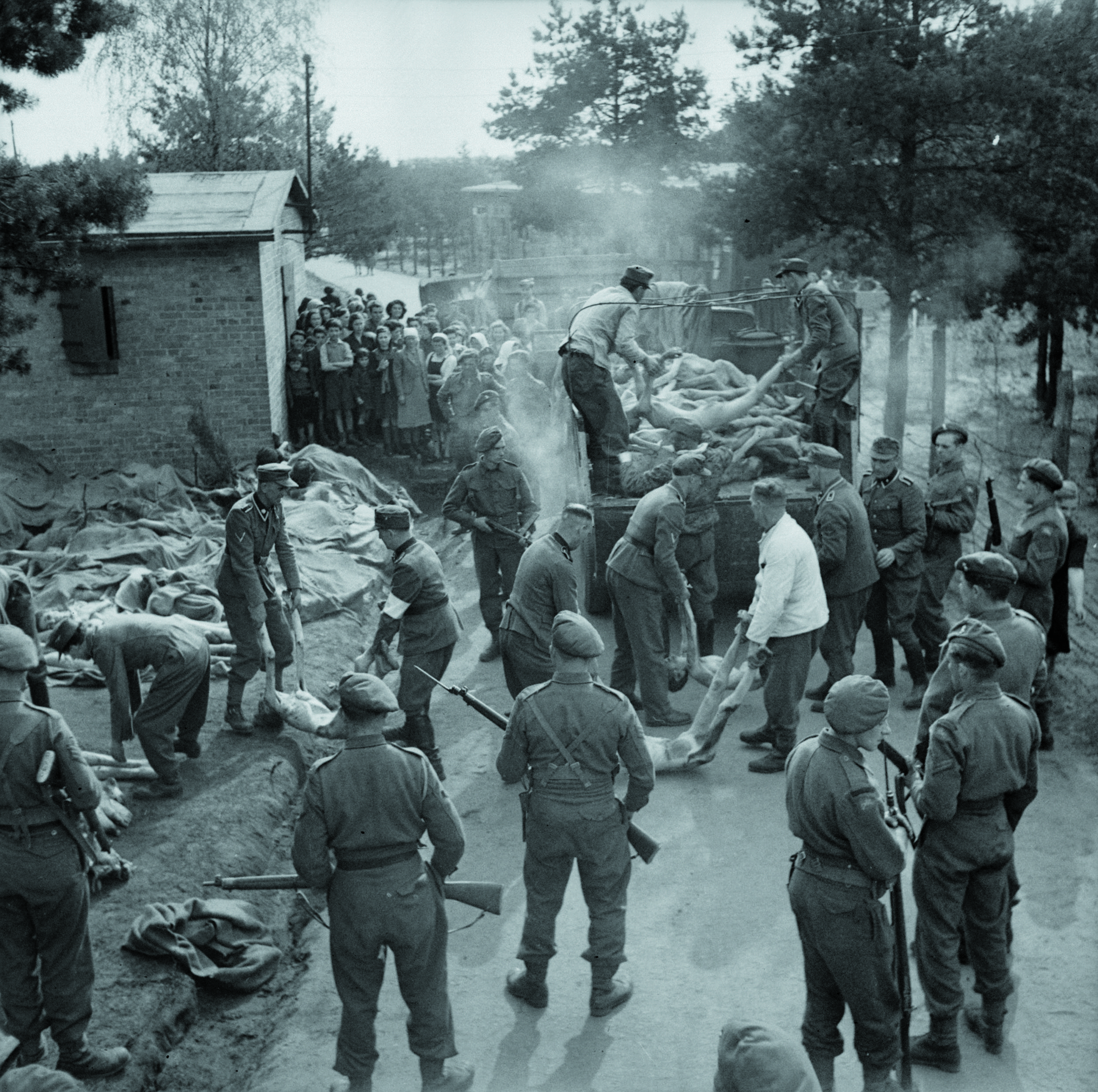 Bergen-Belsen, 17-18 aprile 1945: guardie SS costrette a caricare i cadaveri delle vittime su un camion. In secondo piano, la popolazione locale osserva
