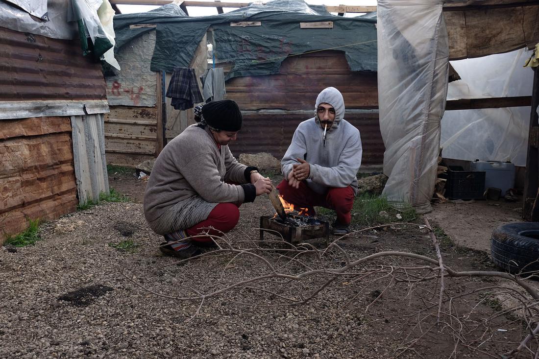 Shadi, 32 anni, e la moglie Samar, 34, cercano di scaldarsi in un insediamento di profughi siriani nel nord del Libano.  