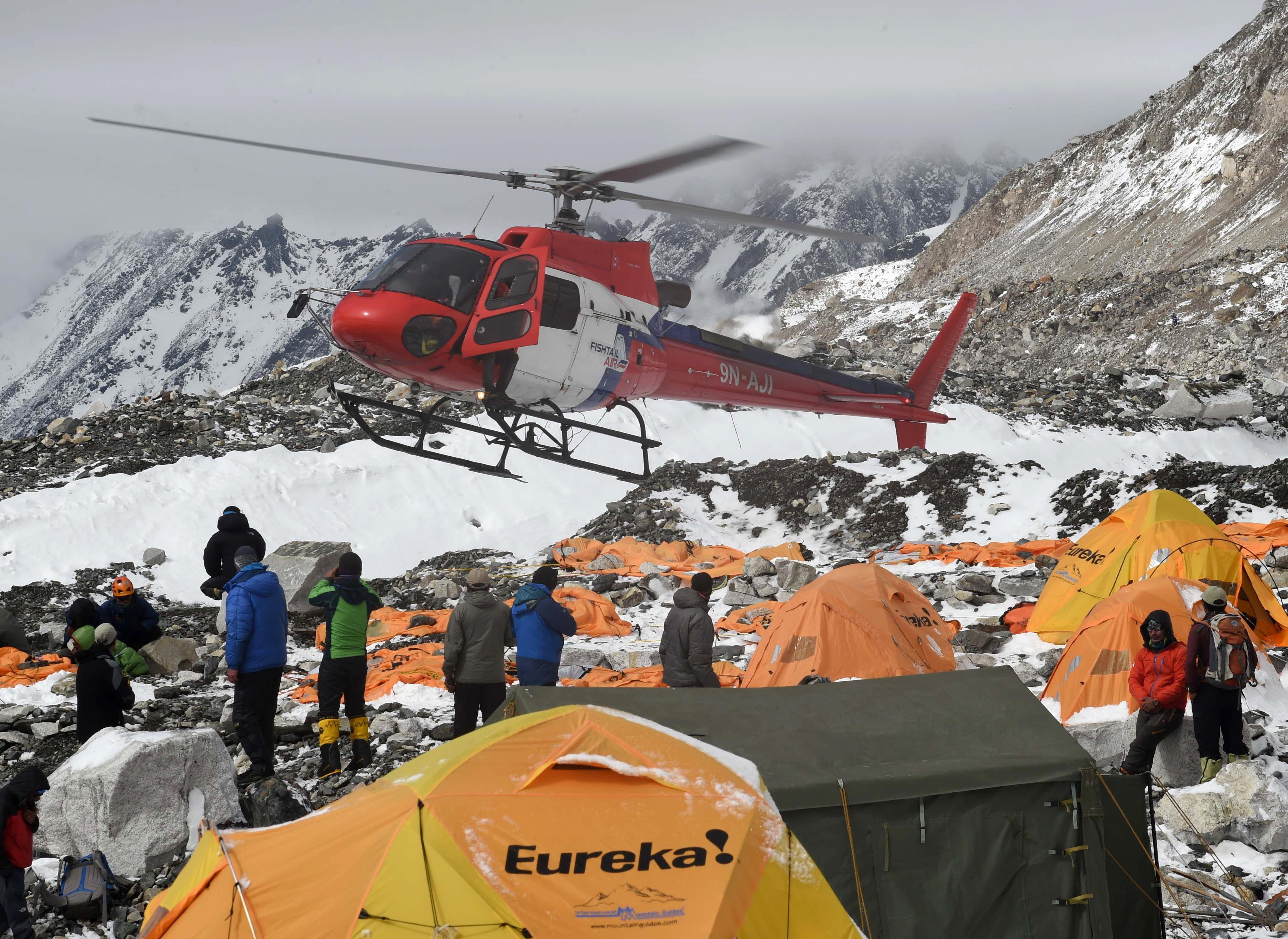 A rescue helicopter prepares to land and airlift the injured from Everest Base Camp on April 26, 2015, a day after an avalanche triggered by an earthquake devastated the camp. Rescuers in Nepal are searching frantically for survivors of a huge quake on April 25, that killed nearly 2,000, digging through rubble in the devastated capital Kathmandu and airlifting victims of an avalanche at Everest base camp. AFP PHOTO/ROBERTO SCHMIDT