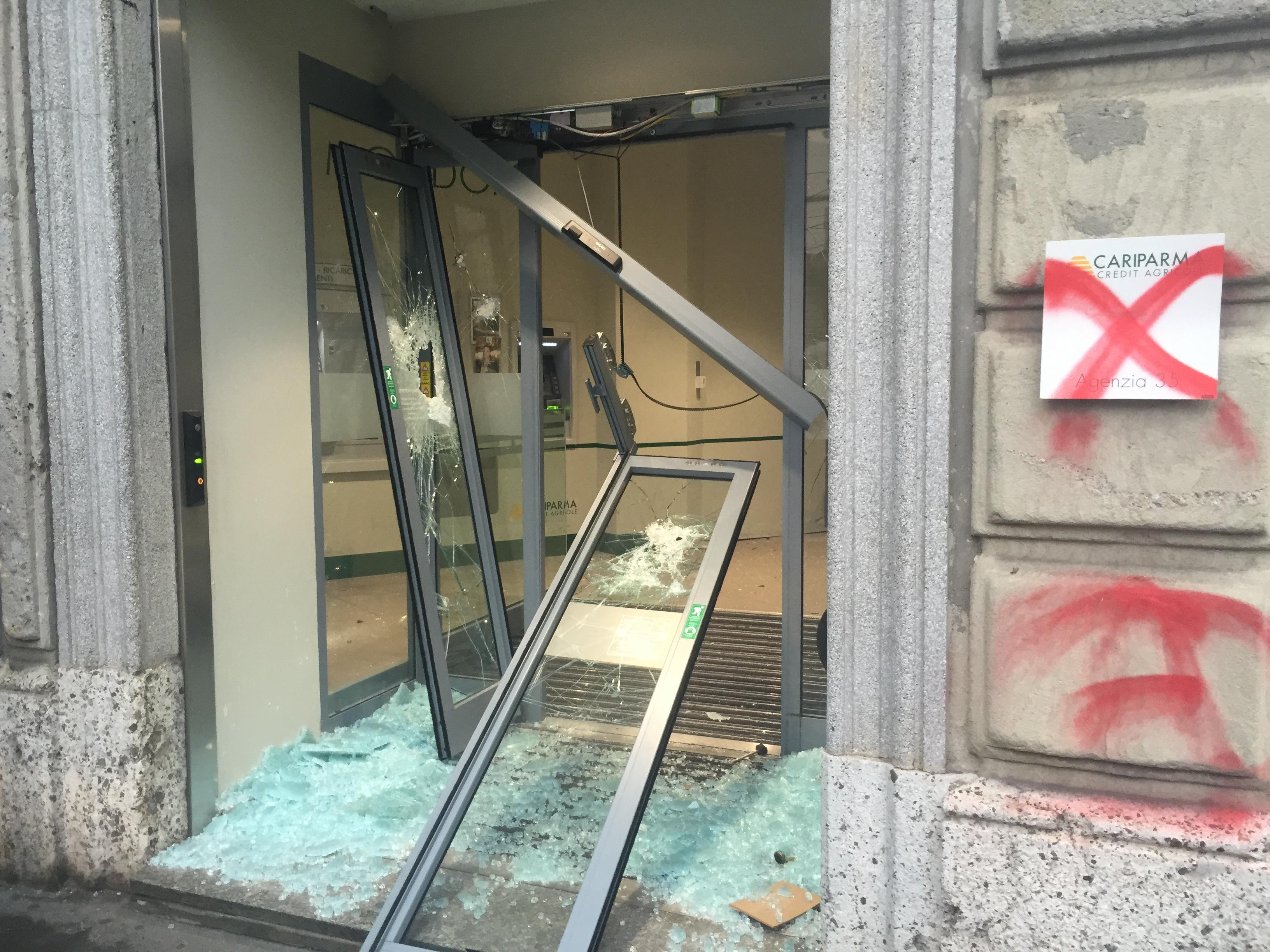 Una vetrina Cariparma devastata durante il corteo 'No Expo'