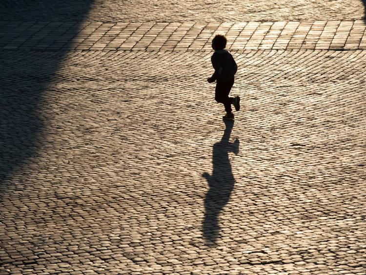 Bambino in piazza a Roma (Infophoto)