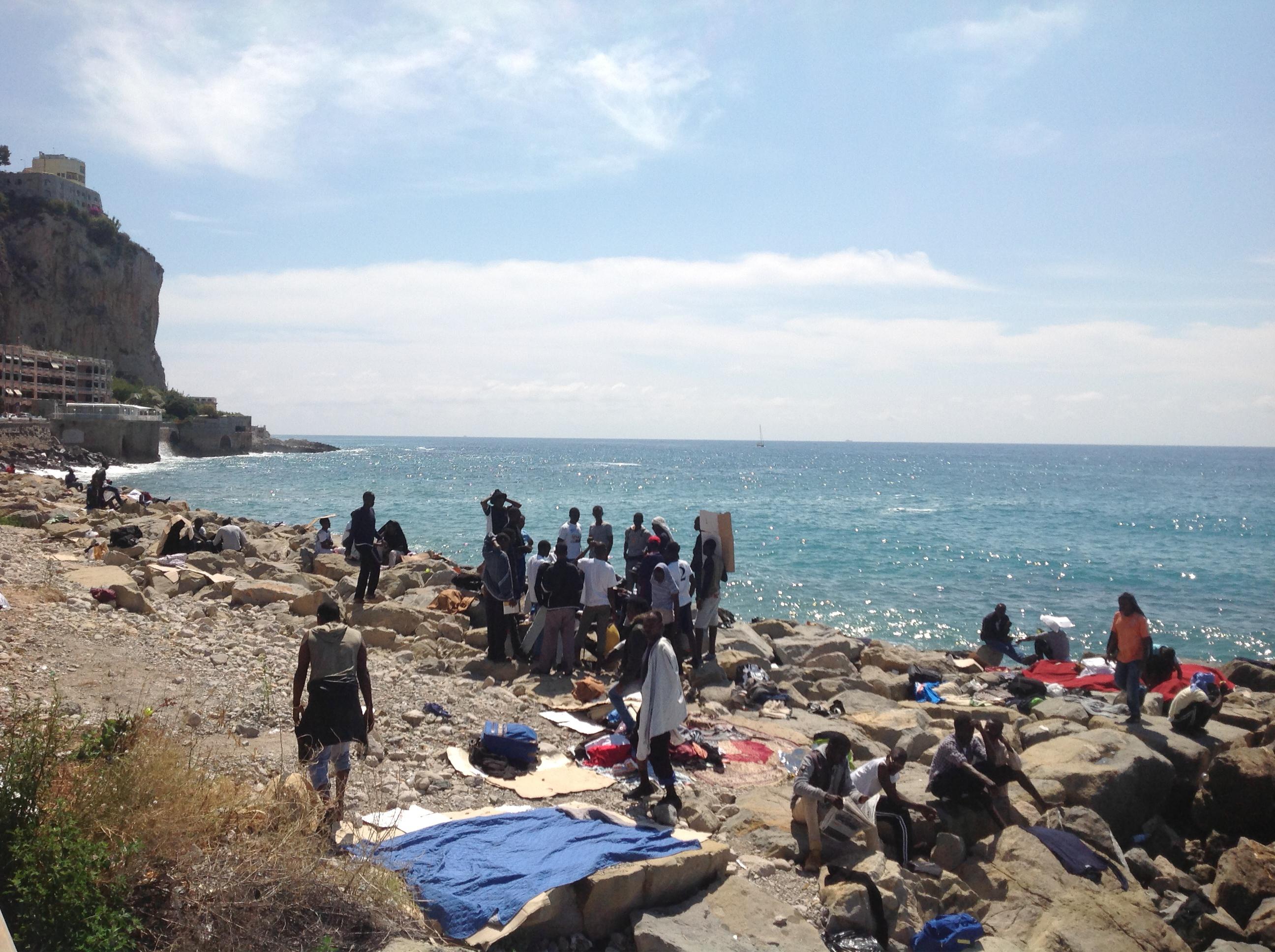 Migranti sugli scogli a Ventimiglia (Foto AdnKronos)