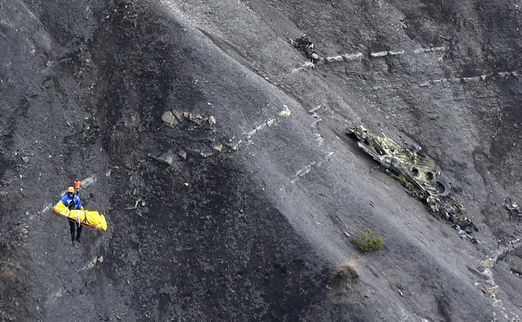 (FILES) This file pictre dated on March 26, 2015 shows an investigator lifted by a French gendarmerie's helicopter passing next to scattered debris above the crash site of the Germanwings Airbus A320 in the French Alps near the southeastern town of Seyne-les-Alpes. French military police said on April 20, 2015 they had wrapped up an operation to recover debris from the crash site in the Alps where a Germanwings plane smashed into the mountainside, leaving 150 people dead.AFP PHOTO / ANNE-CHRISTINE POUJOULAT - AFP