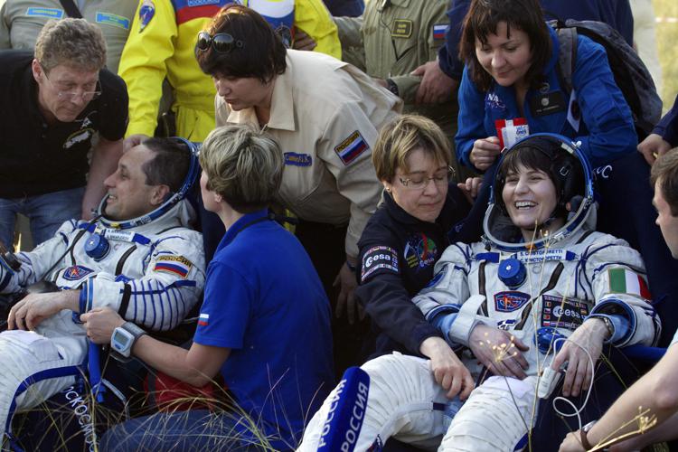 Russian cosmonaut Anton Shkaplerov, left, and Italian astronaut Samantha Cristoforetti rest in chairs outside the Soyuz TMA-15M space capsule after they and U.S. astronaut Terry Virts landed in a remote area outside the town of Dzhezkazgan, Kazakhstan, on June 11, 2015. Three astronauts landed in Kazakhstan on June 11, safely returning to Earth after their flight back home was delayed for a month by a Russian rocket failure. AFP PHOTO / POOL / IVAN SEKRETAREV - AFP