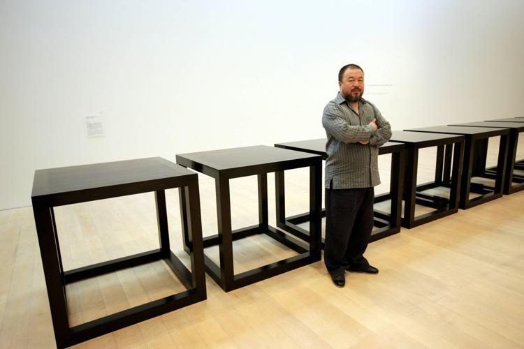 L'artista cinese Ai Weiwei, in una foto del 2009 a Tokyo, accanto a una delle sue opere chiamata 