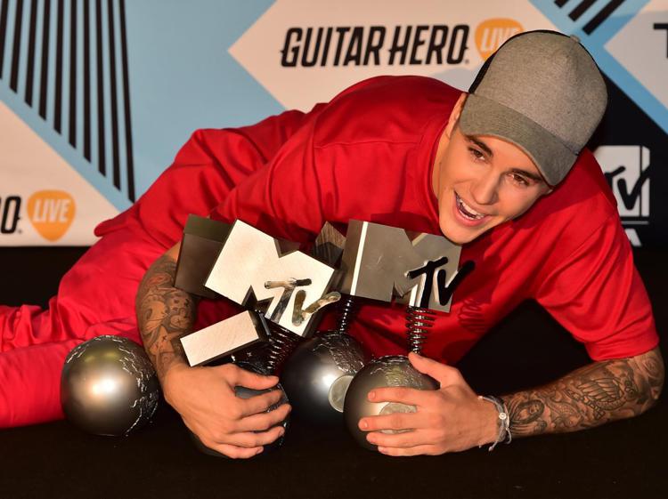 Justin Bieber posa con i suoi cinque premi (Foto AFP) - AFP
