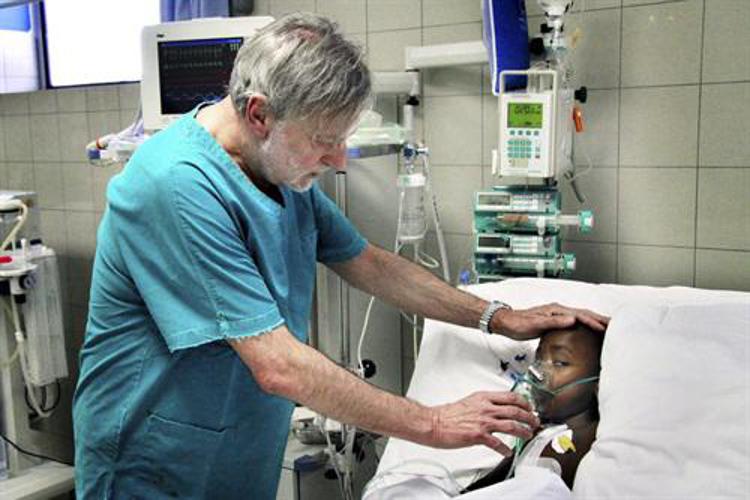 Gino Strada con un piccolo paziente durante una missione umanitaria