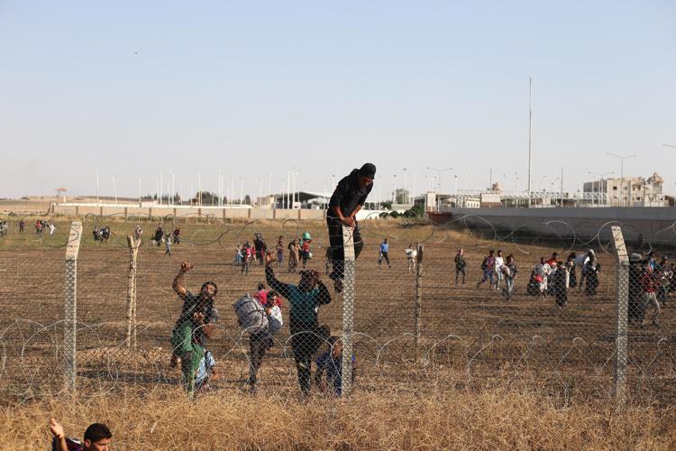 Syrians try to climb the fence while hundreds of refugees wait at the Syrian side of the border crossing in Akcakale, Sanliurfa province, south-eastern Turkey, June 14 2015. They are trying to cross to the Turkish side as they are fleeing from the fighting between the Kurdish People's Protection Units (YPG) military group and Islamic State (ISIS). Photo by Ebrahem Khadir/ UPI - Infophoto - INFOPHOTO
