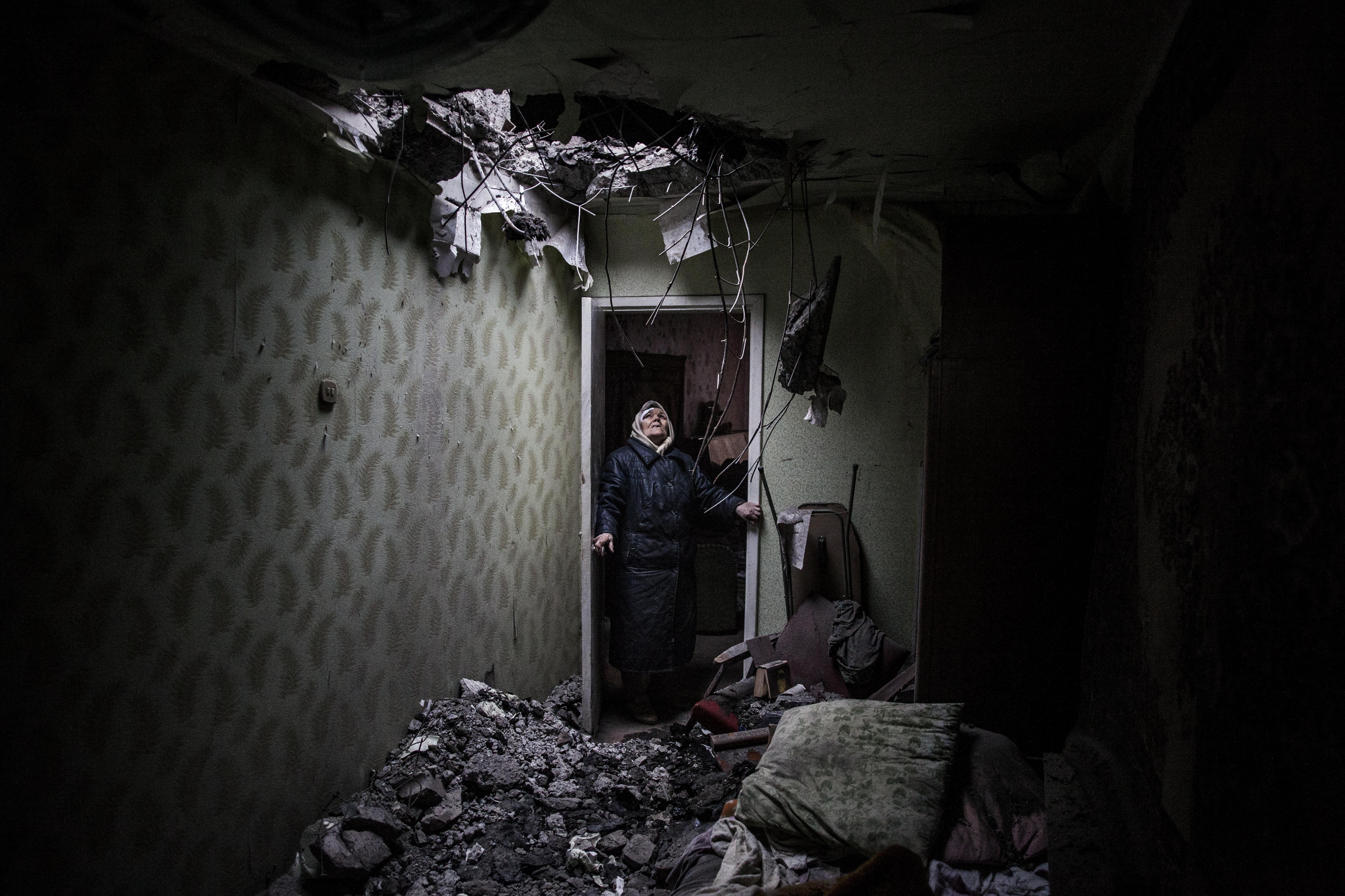 Galina, 86 anni, guarda il buco dove una granata ha colpito il suo appartamento nel quartiere Kievsky a Donetsk, Ucraina. (Foto di Manu Brabo)