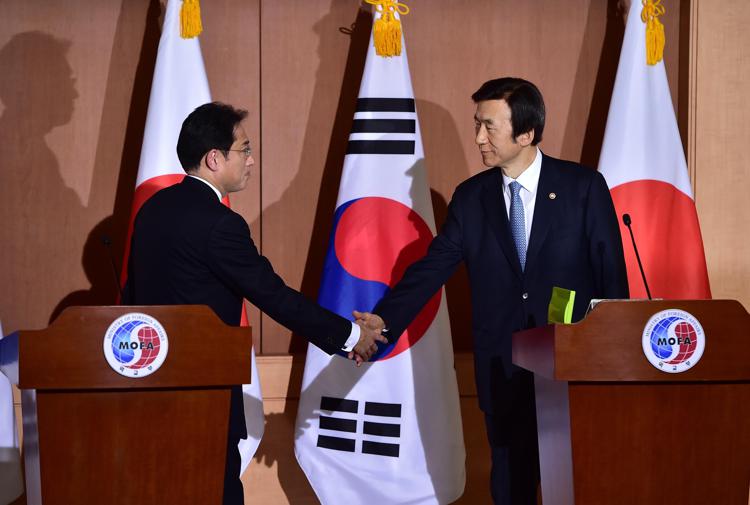 Il ministro degli Esteri giapponese Fumio Kishida stringe la mano al suo omologo sudcoreano Yun Byung-Se (Afp) - AFP