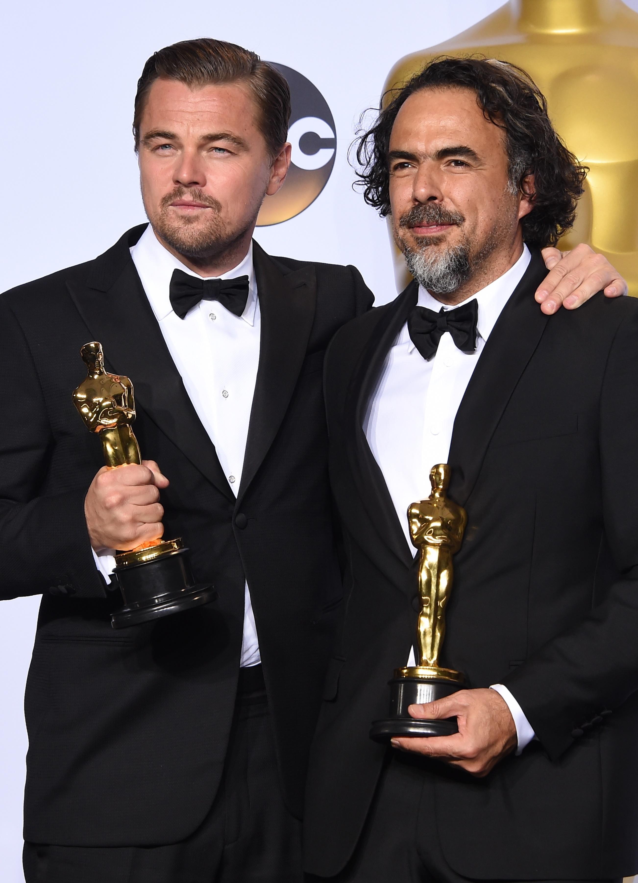 Leonardo DiCaprio in Armani, con il primo premio Oscar come miglior attore protagonista accanto al regista messicano Alejandro G. Iñárritu in Prada, premiato come miglior regista per 'The Revenant' (Afp)
