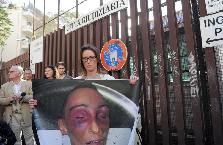 Ilaria Cucchi davanti al Tribunale di Roma mostra la foto del cadavere martoriato del fratello Stefano (Fotogramma)
