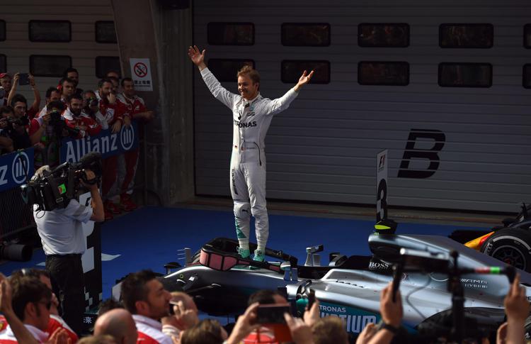 Nico Rosberg festeggia dopo la vittoria nel Gp di Shanghai, in piedi sulla sua Mercedes AMG Petronas (AFP PHOTO)