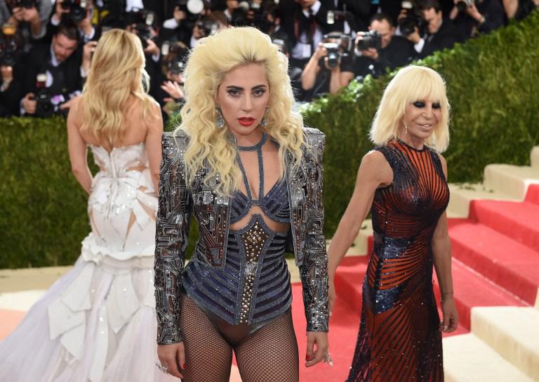 Lady Gaga in Versace sul red carpet con Donatella Versace e di spalle Kate Hudson (Foto Afp)