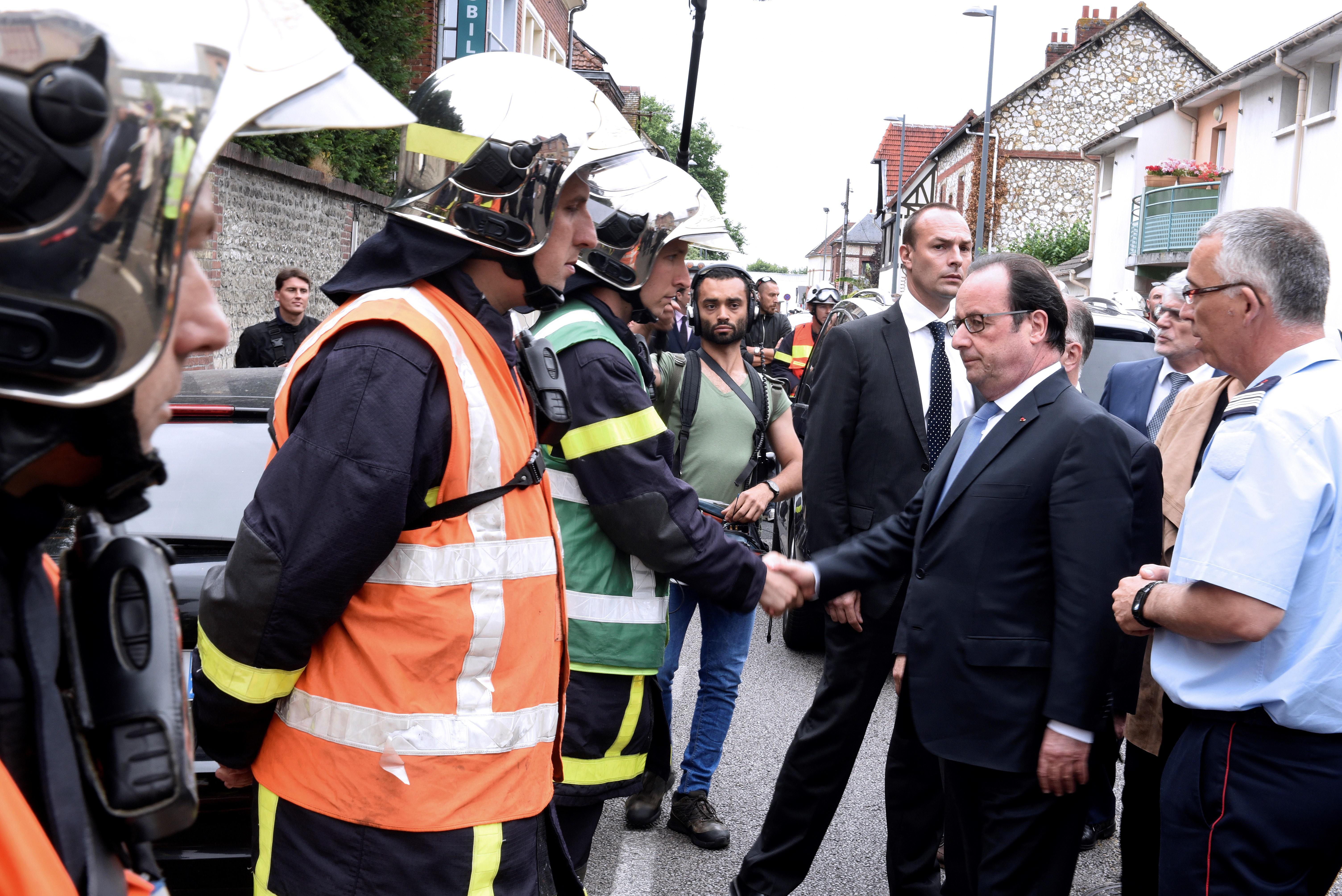 Il presidente francese Francois Hollande stringe la mano ai vigili del fuoco (Foto Afp)