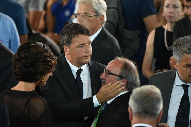 Il presidente del Consiglio Renzi abbraccia il sindaco di Arquata (Foto Afp) - AFP