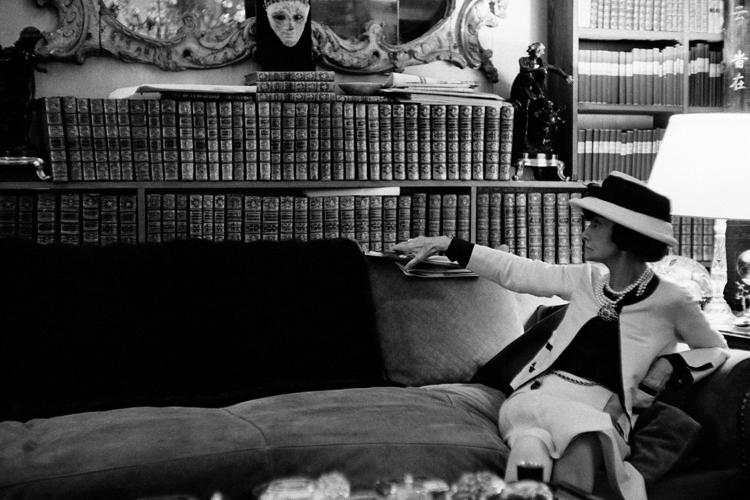 Gabrielle Chanel sul divano, mentre guarda la sua biblioteca, luglio 1962 (foto di Douglas Kirkland) © Douglas Kirkland - DOUGLAS KIRKLAND