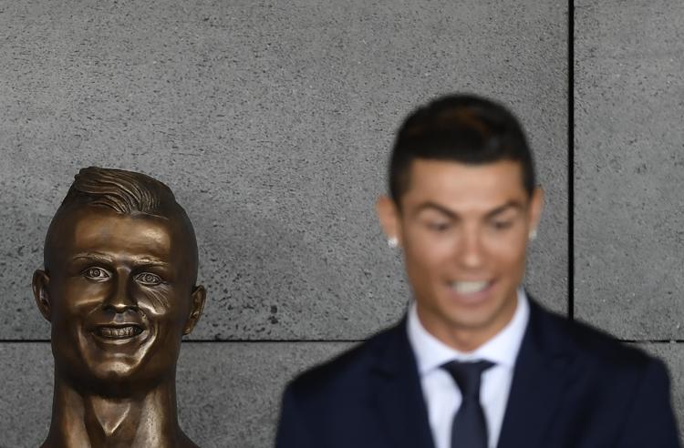 Cristiano Ronaldo e la statua di Emanuel Santos (Foto Afp) - AFP
