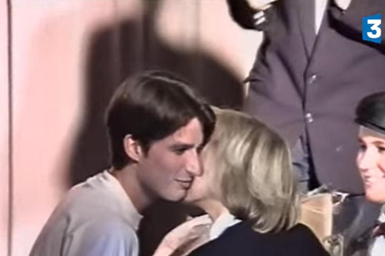 Un giovane Emmanuel Macron bacia sulla guancia Brigitte Trogneux, sua ex insegnante e ora moglie (fermo immagine dal video)