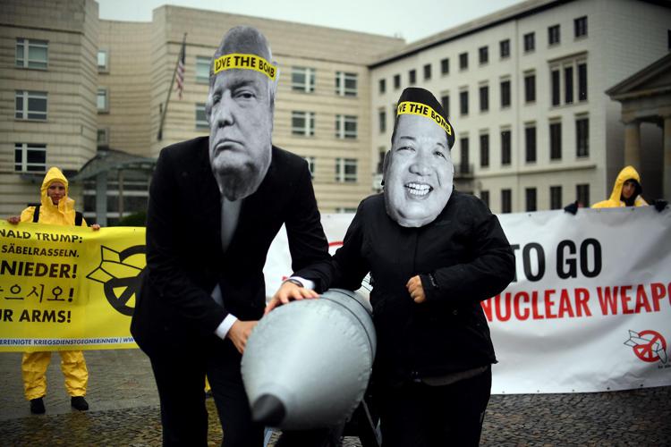 Attivisti tedeschi con le maschere di Trump e Kim Jong-un manifestano a favore della la campagna internazionale per abolire le armi nucleari (Afp) - AFP