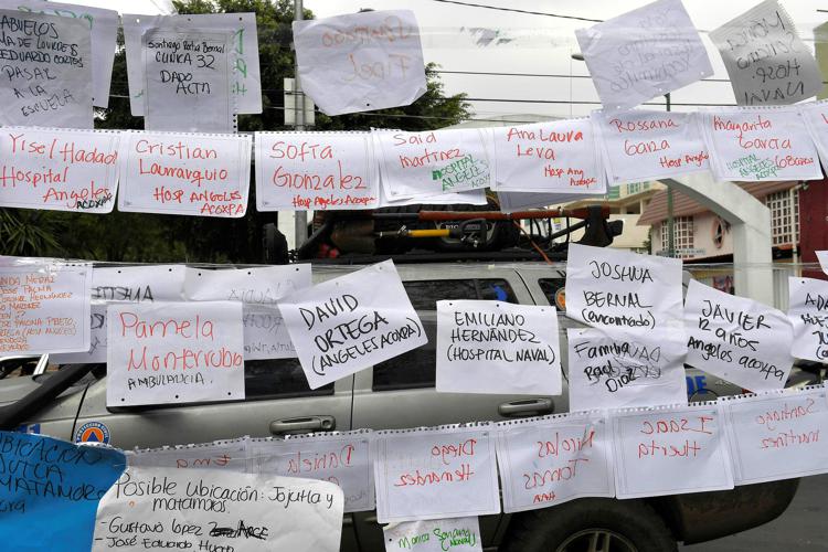 Alcuni foglietti con i nomi delle persone ancora disperse (Afp) - AFP