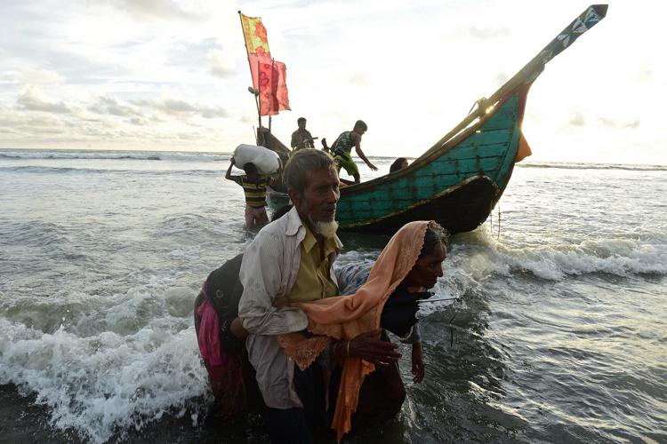 Alcuni profughi Rohingya scendono da una barca dopo aver attraversato il confine di Myanmar (Afp) - AFP