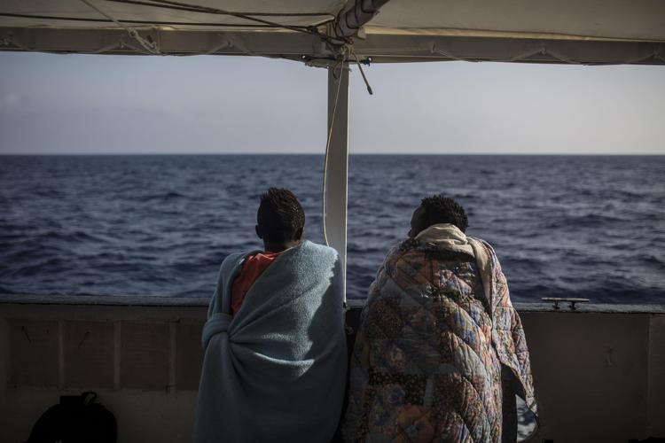 Migrants look at the sea from the deck of the NGO Proactiva Open Arms boat on July 2, 2018. The NGO Proactiva Open Arms boat, that had rescued 59 migrants as they tried to cross the Mediterranean from Libya, docked in Barcelona on 4 July 4, 2018 after Italy and Malta refused access. /Photo: AFP
