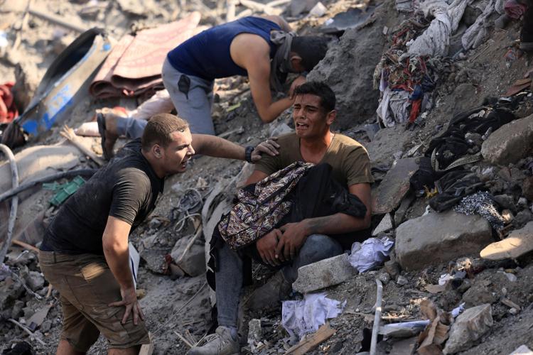 Un uomo si dispera tra le macerie di Gaza - Afp