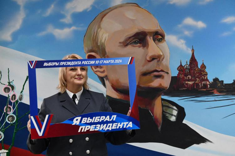 Selfie con il ritratto di Putin nel giorno delle elezioni in Russia - Afp