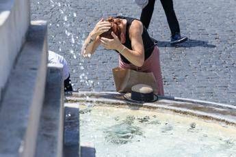 Donna si bagna la testa nella fontana per rinfrescarsi - (Ipa)