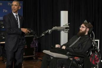 Obama stringe la mano robotica di un uomo paralizzato Obama stringe la mano robotica di un uomo paralizzato