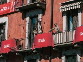 A Milano tavoli usati come ponti tra i balconi per far dialogare i condomini A Milano tavoli usati come ponti tra i balconi per far dialogare i condomini