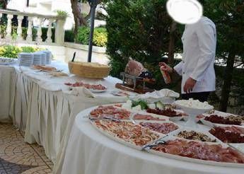 Mosche sul buffet e il cameriere spruzza l'insetticida tra i piatti Mosche sul buffet e il cameriere spruzza l'insetticida tra i piatti