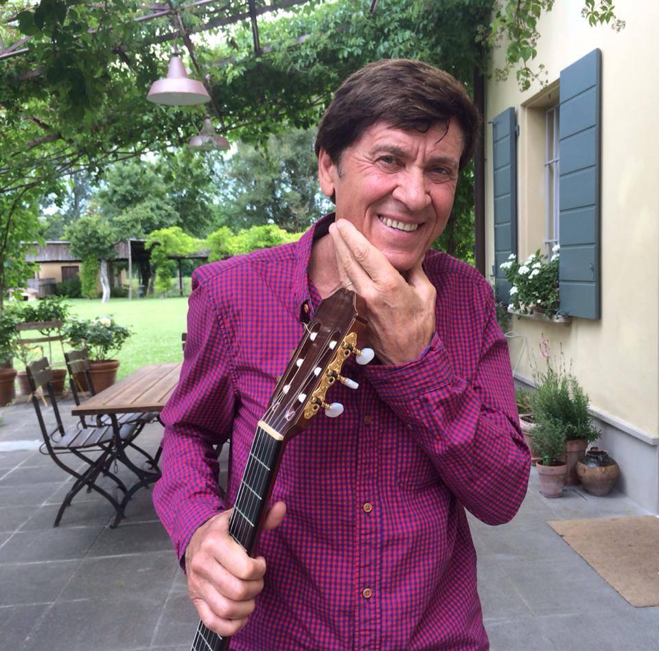 Gianni Morandi imbraccia la chitarra davanti all'ingresso della sua casa di San Lazzaro