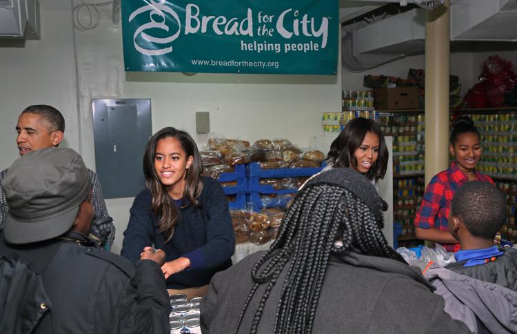 Il presidente Obama e la famiglia consegnano pacchi per la cena del Ringraziamento  a mensa per i poveri.  (Foto Infophoto) 