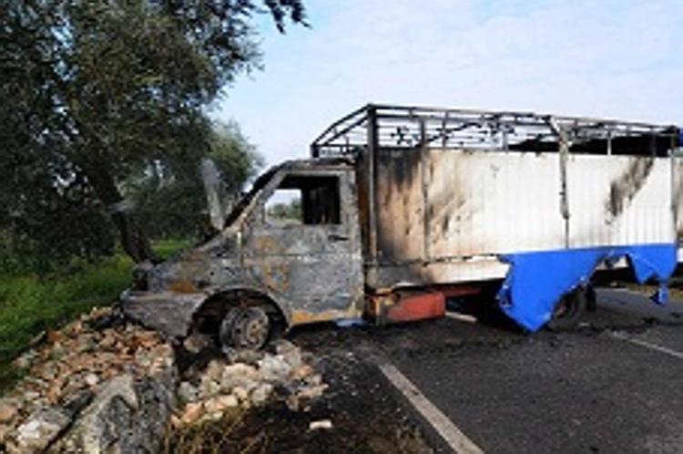 Un autocarro incendiato per compiere una rapina (Infophoto).