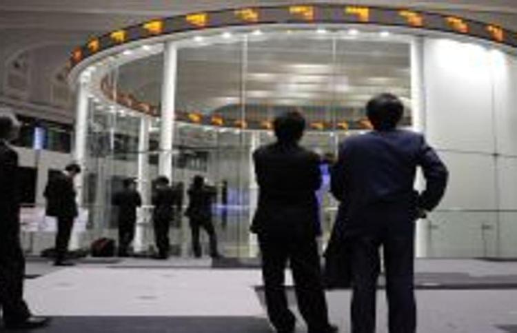 Operatori guardano le quotazioni alla Borsa di Tokyo. Infophoto/Xinhua
