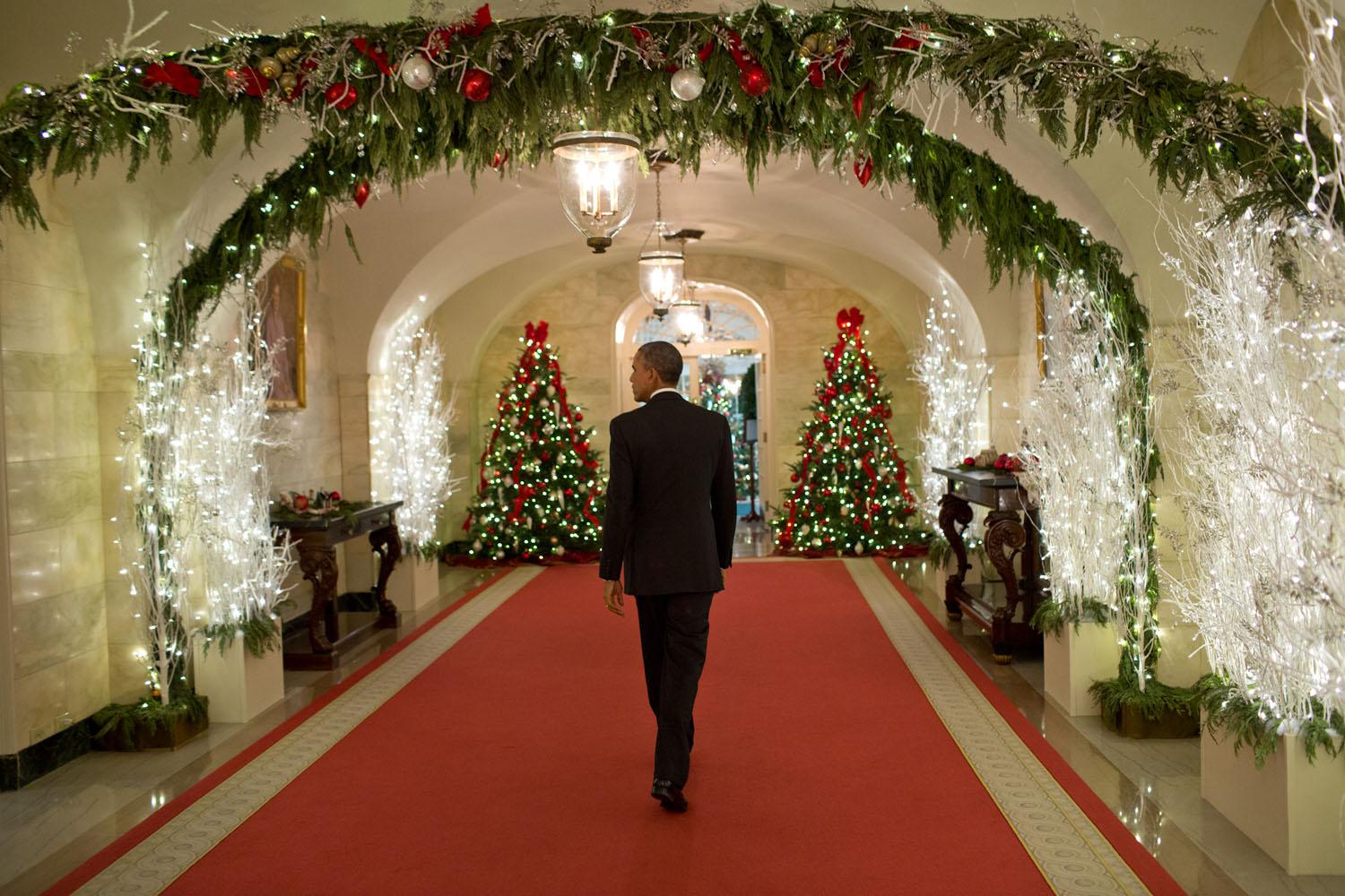 Obama cammina nei corridoi della Casa Bianca addobbati per Natale il 12 dicembre 2014.