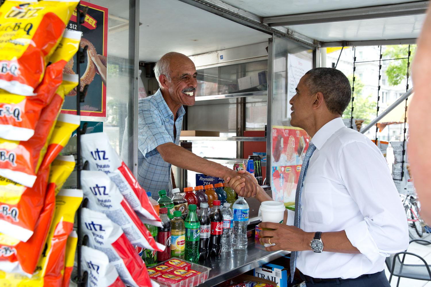 Uscito un pomeriggio a fare una passeggiata sulla Pennsylvania Avenue, Obama si ferma a salutare il venditore di un chiosco di origine afghana il 9 giugno 2014. 