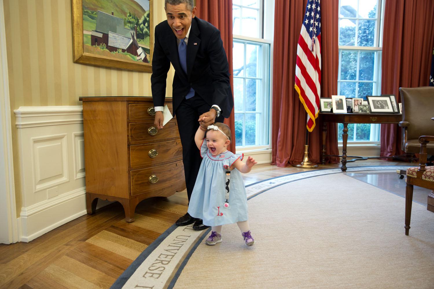 Obama insegna a camminare a Lincoln Rose Smith, la figlia di un anno dell'ex vice addetta stampa Jamie Smith il 4 aprile 2014 nel suo ufficio Ovale. 