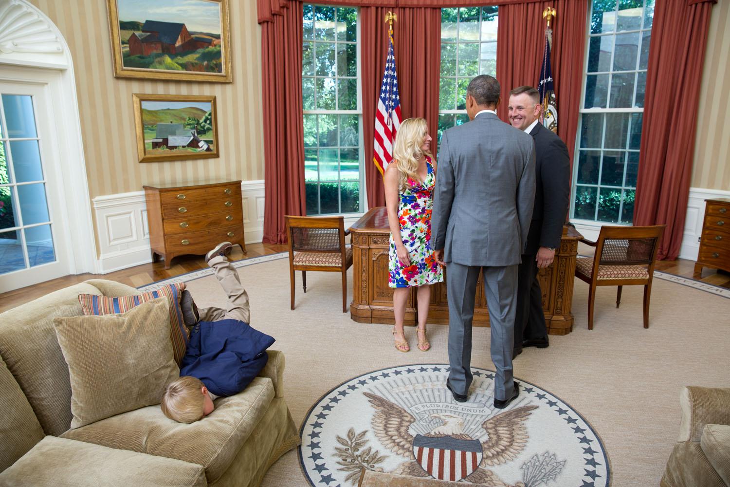 Il figlio di un agente del Secret Service non appare intimidito dall'ufficio Ovale, mentre i suoi genitori salutano Obama il 23 giugno 2014. 