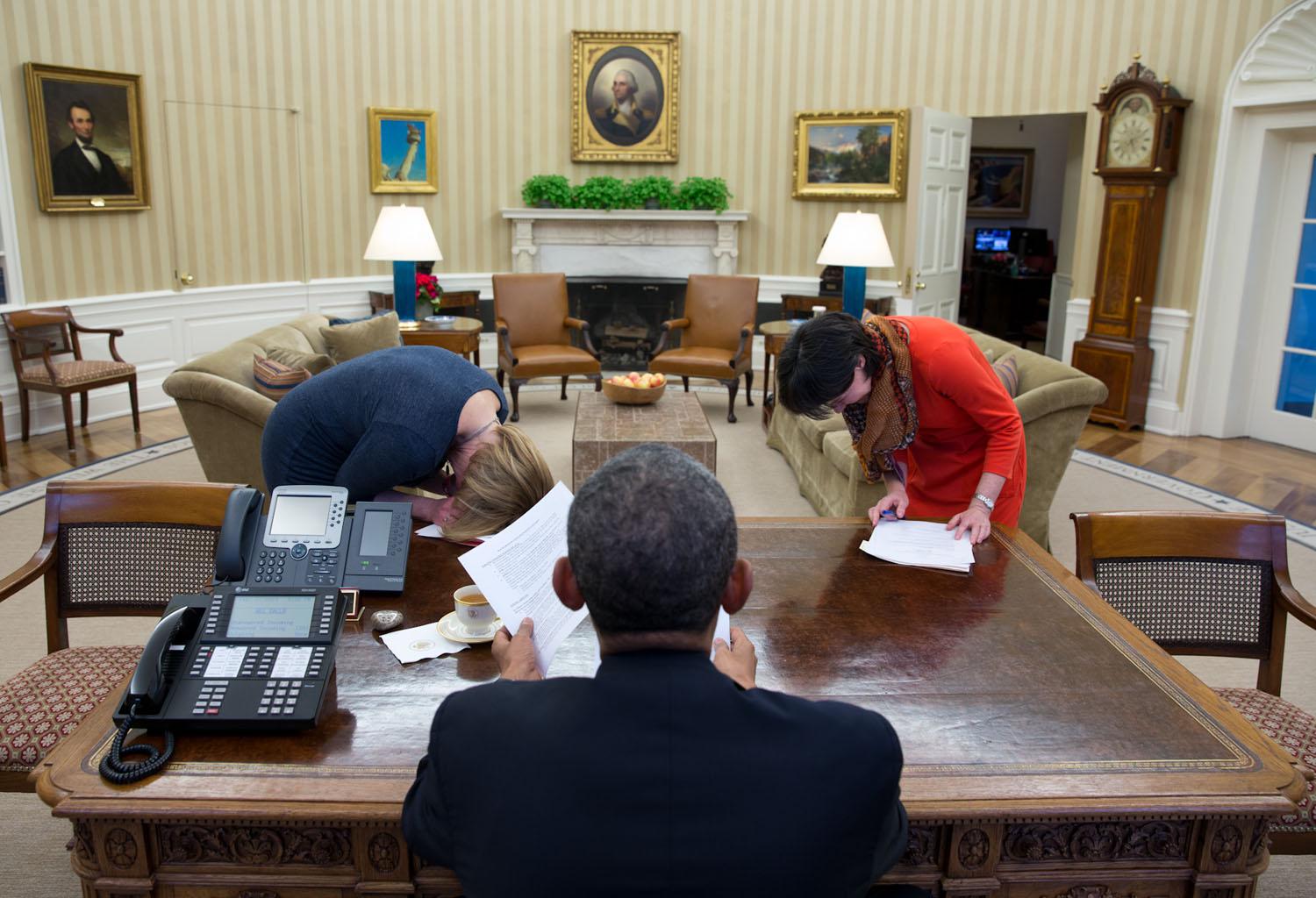 Due assistenti scoppiano a ridere per una battuta di Obama il 7 febbraio 2014.
