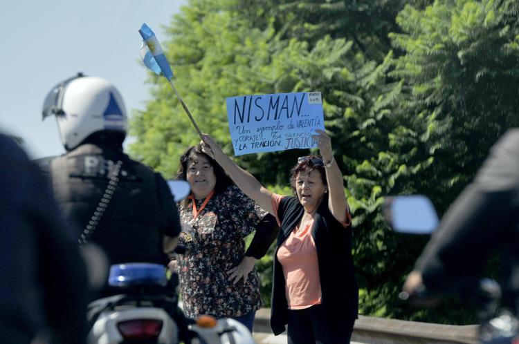 Un cartello di protesta al passaggio del convoglio funebre di Alberto Nisman.  (Infophoto)