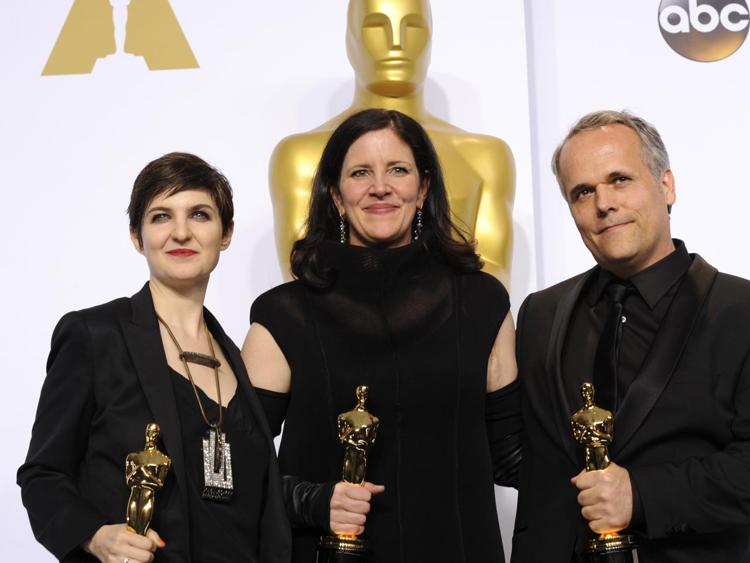 Laura Poitras, con a fianco Mathilde Bonnefoy e Dirk Wilutzky, sul palco degli Oscar