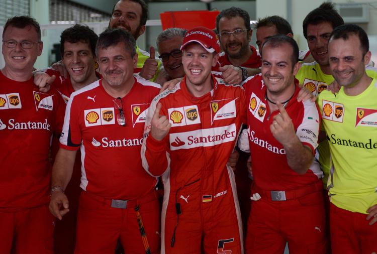 Sebastian Vettel circondato dagli uomini della Ferrari dopo la prima vittoria con la Rossa a Sepang (Foto AFP)