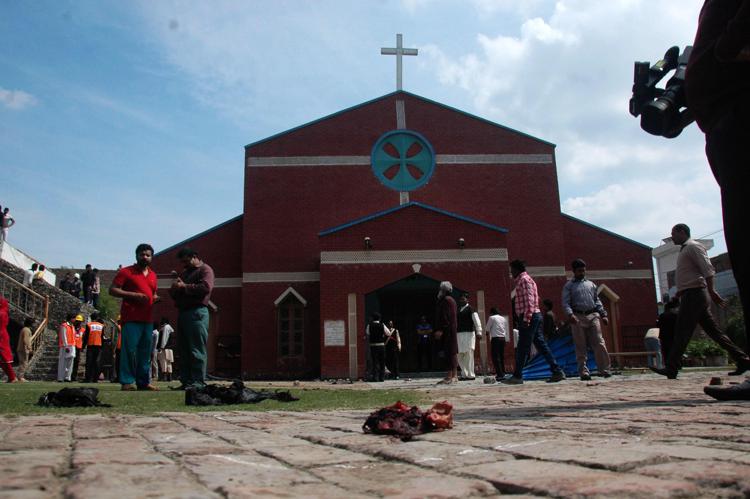 Cristiani pakistani davanti a una delle chiese dove sono avvenute le esplosioni (foto Infophoto)