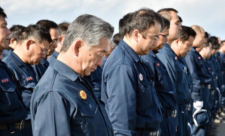 Agenti di polizia osservano un minuto di silenzio in memoria delle vittime del 2011 (Foto Afp) 